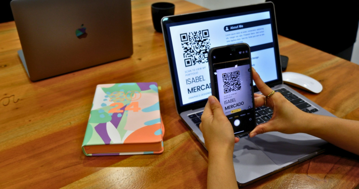 a person sitting at a table with a laptop and a cell phone